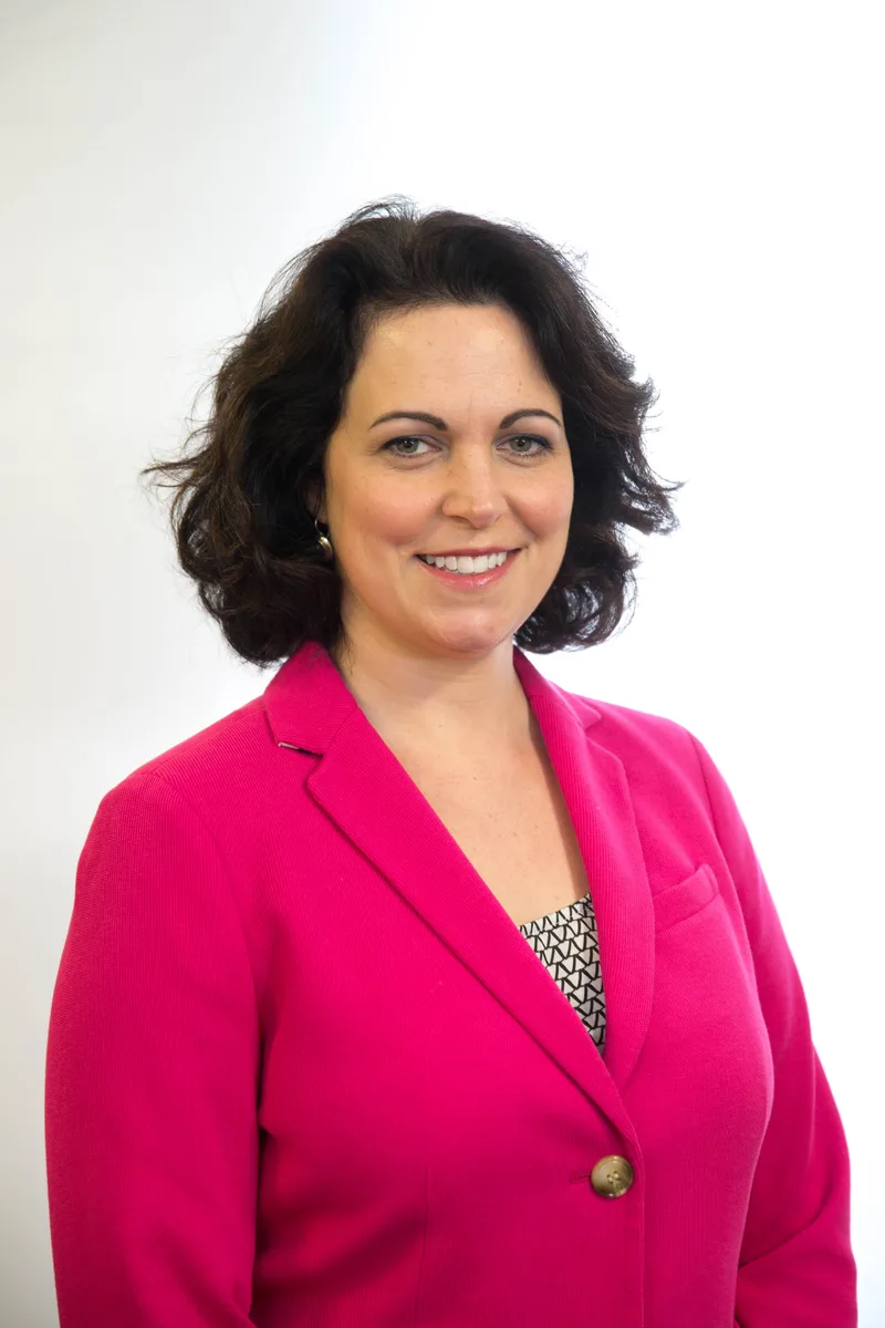 Adrienne Hancock in a professional portrait wearing a bright pink blazer